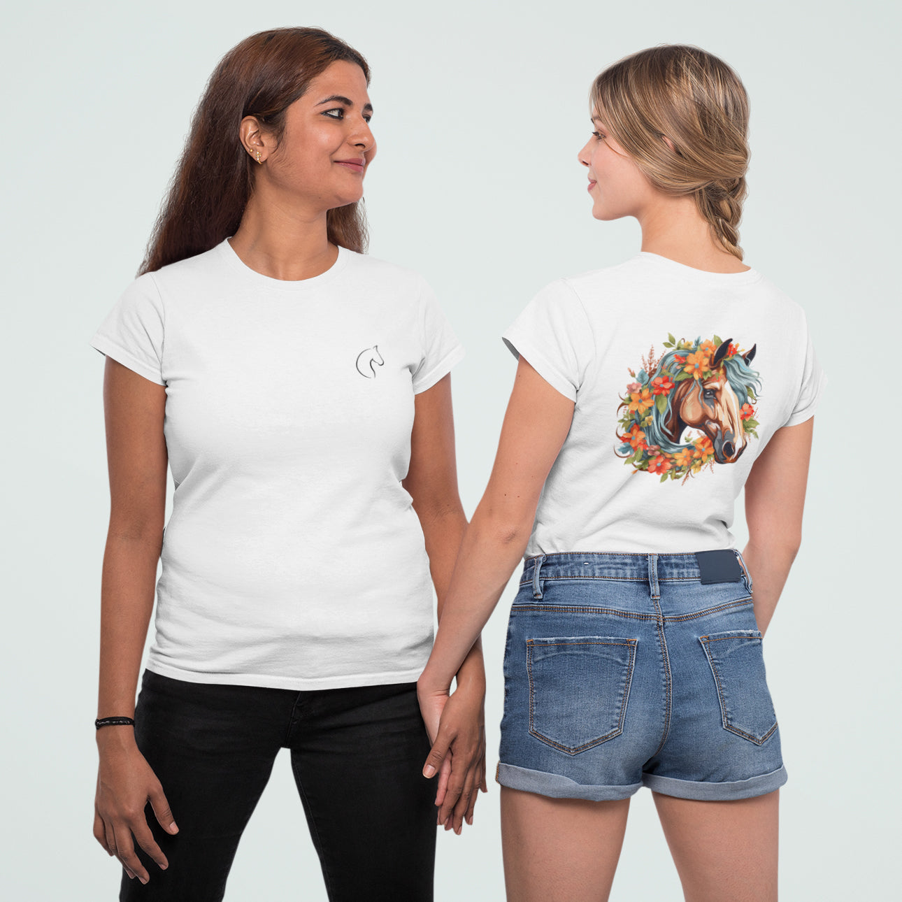 Zwei Frauen die ein Tshirt bewerben, die linke Frau zeigt die Vorderseite auf der ein kleines Pferdelogo auf Brusthöhe auf einem weißen Tshirt zu sehen ist, die andere Frau zeigt die Rückseite, die ein blumiges und buntes pferdebild zeigt
