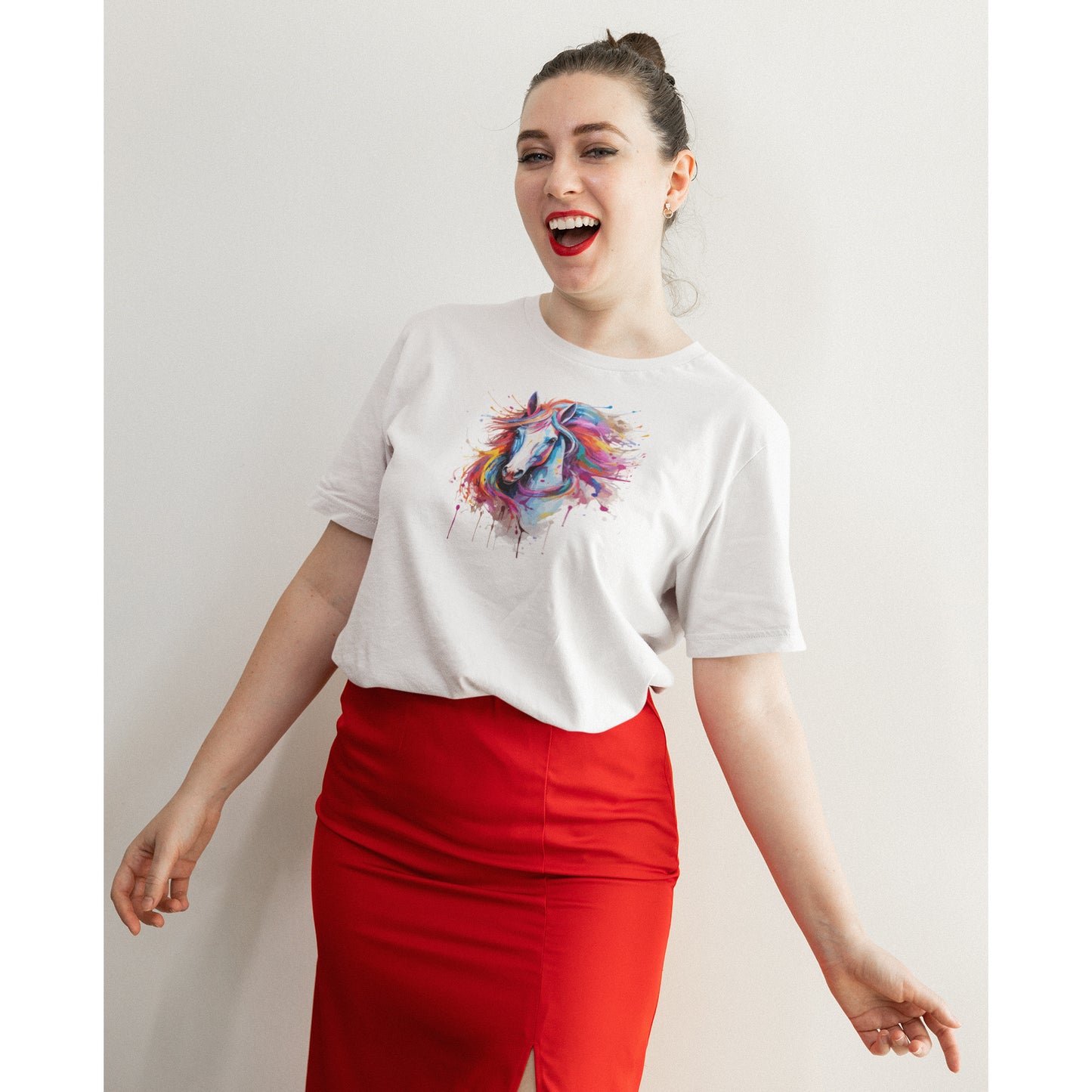 Eine junge Frau mit Lippenstift und einem Roten Rock trägt ein weißes Tshirt mit einem bunten Pferdeaufdruck vor einer weißen Wand