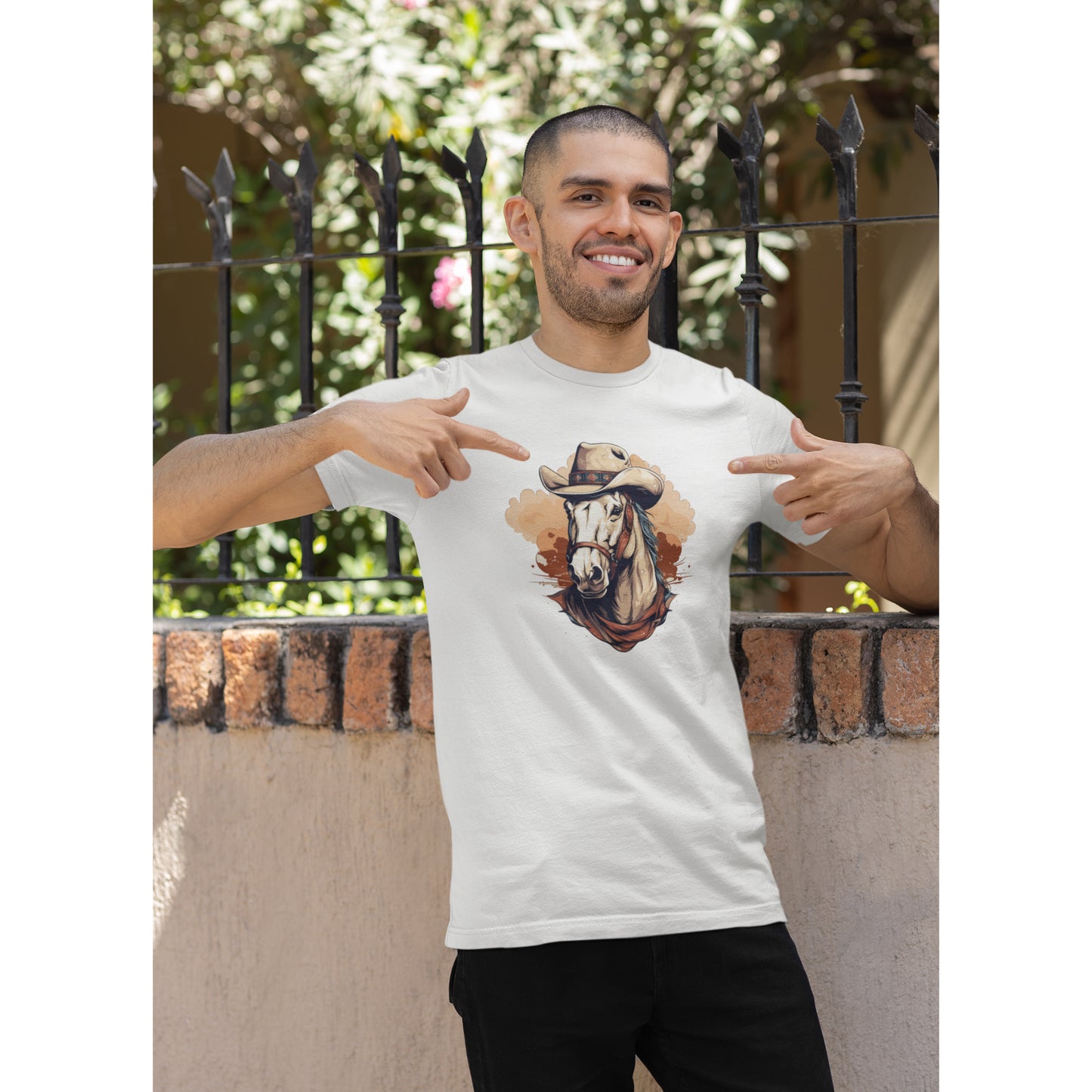 Ein weißes Tshirt mit einem Aufdruck eines im Comic-Stil gehaltenen Westernpferdes mit einem Cowboyhut getragen von einem Mann mit kurzen Haaren vor einer Mauer.